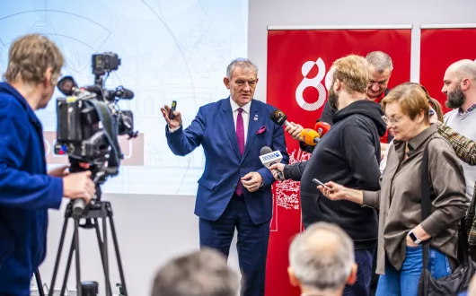 rektor wypowiadający się do mikrofonów mediów