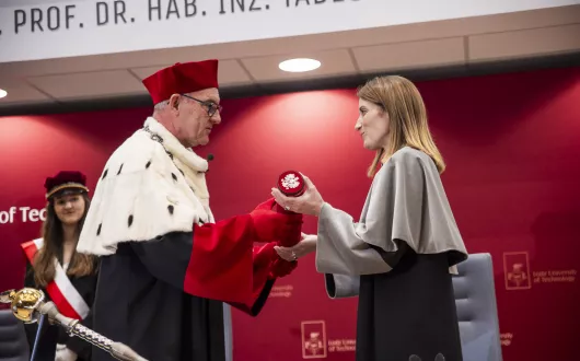 rektor wręczający elegancką tubę na dokumenty pochylonej lekko kobieci