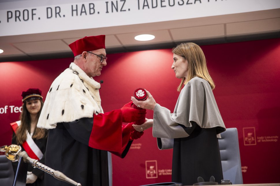 rektor wręczający elegancką tubę na dokumenty pochylonej lekko kobieci
